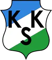 a blue white and green shield with the letters kk s on it