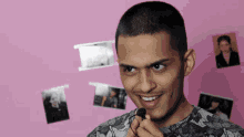 a man with a shaved head is smiling in front of a pink background