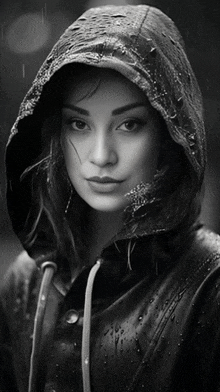 a black and white photo of a woman wearing a hood