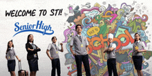 a group of people standing in front of a wall that says welcome to sti senior high