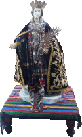 a statue of a woman with a crown on her head is sitting on a colorful blanket