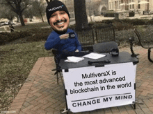 a man sitting at a table with a sign that says " change my mind "