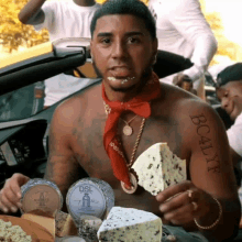 a man with a tattoo on his arm eating cheese