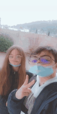 a boy wearing glasses and a girl wearing a mask pose for a picture