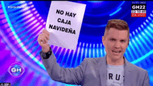 a man holds up a sign that says no hay caja navidena