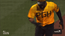 a man wearing a yellow pgh jersey is running on a baseball field