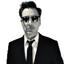 a man in a suit and tie is wearing sunglasses and looking at the camera .