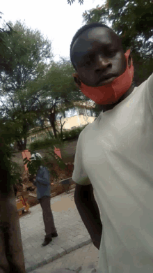 a man wearing an orange mask stands in front of a building