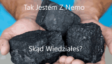 a person holding a pile of coal in their hands with the words tak jestem z nemo