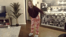 a woman is dancing in a living room in front of a refrigerator that says ' i love you '