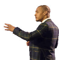 a man in a plaid suit holds his hand out