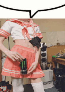 a person in a pink skirt holds a can of monster energy drink