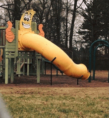 a playground with a yellow slide that looks like a banana giving a thumbs up