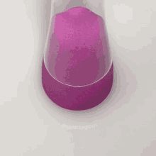 a bottle of purple sand is sitting on a white table