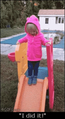 a little girl in a pink coat is standing on a slide with the words " i did it " below her