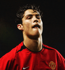 a man wearing a red shirt with the word manchester on the front