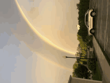 a parking lot with a rainbow in the sky and a street sign that says no parking