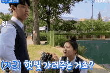 a boy and a girl are standing next to each other in a park with a sign that says playlist