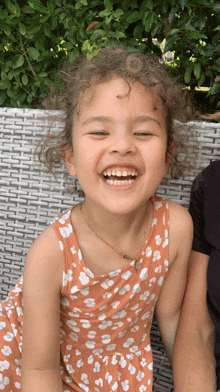 a little girl wearing a leopard print dress is smiling