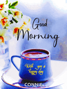 a blue cup of coffee on a saucer with the words good morning wish you a happy day