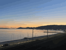 a sunset over a body of water with a few hills in the background