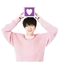 a young man in a pink sweater holds a purple box with a heart on it