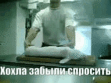 a man is cutting a piece of meat on a cutting board in a kitchen