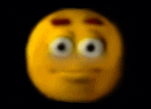 a blurred image of a yellow smiley face with big eyes on a black background .