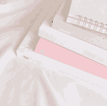 pink and white books stacked on top of each other with one titled map of the soul