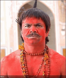 a man with red paint on his face is wearing a necklace .