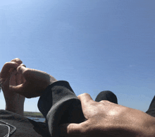 a person holding another person 's hand with a blue sky behind them