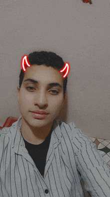 a young man with devil horns on his head takes a selfie