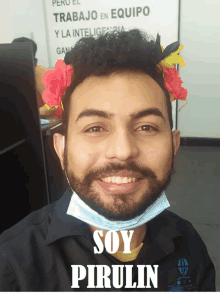 a man wearing a mask and flowers in his hair has the word soy pirulin on his shirt