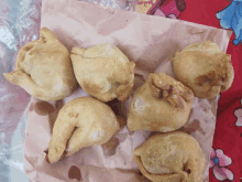 a bunch of fried food sitting on a piece of brown paper