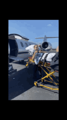 a person on a stretcher being loaded into a plane