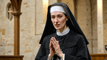 a nun with her hands folded in prayer