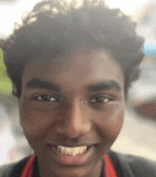 a close up of a young man 's face with a smile on his face .