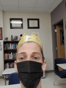 a young man wearing a black mask and a gold crown