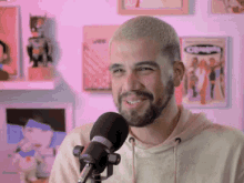 a man with a beard is smiling in front of a microphone with a comic book on the wall behind him that says champions