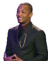 a man in a black suit with a gold chain around his waist