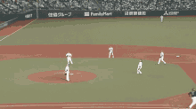 a baseball game is being played on a field sponsored by familymart