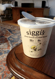 a container of siggi 's plant-based coconut blend sits on a wooden table