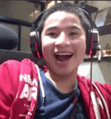 a young man wearing headphones and a red hoodie that says new york