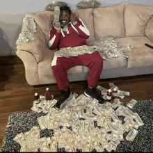 a man is sitting on a couch surrounded by money and bottles of alcohol