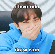 a man in a blue hoodie is covering his mouth with his hand and the caption i love rain ikaw rain