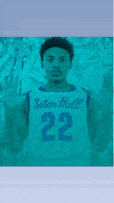 a man wearing a seton hall 22 jersey holds up his hands