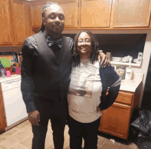 a man in a bow tie stands next to a woman in a white shirt with a picture of a man on it