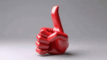 a red hand is giving a thumbs up on a gray background .