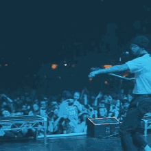 a man playing a guitar in front of a crowd wearing a shirt that says ' stars ' on it