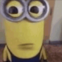 a close up of a minion wearing goggles and making a face .